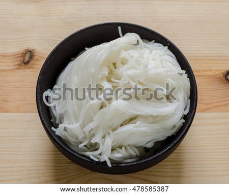 Close up of Thai vermicelli eaten with curry, Thai Food, rice vermicelli in black bowl on wooden table