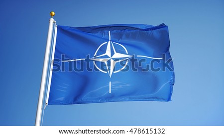 NATO flag waving against clean blue sky, close up, isolated with clipping path mask alpha channel transparency