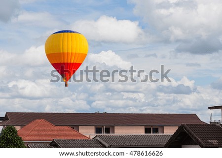 Color hot air balloon over roof in blue sky