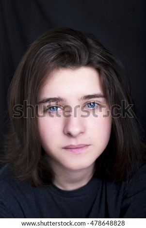 A portrait of a handsome blue eyes teenager on dark background