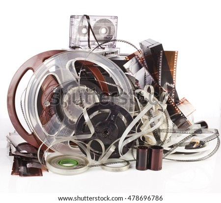 Vintage film camera rolls, old audio and video casettes with tape and foto strip isolated on white background