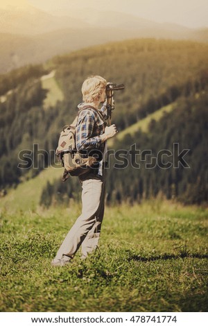 traveler on top of a mountain  looking through binoculars and looking through binocular. vintage picture