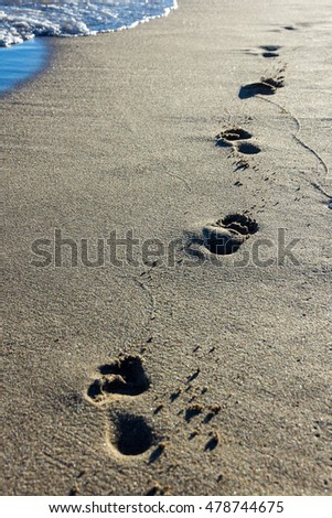 Footprints in the sand walking on the beach