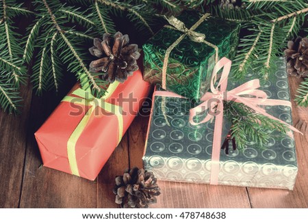 Gifts and Christmas balls lying under Christmas tree branches. Vintage