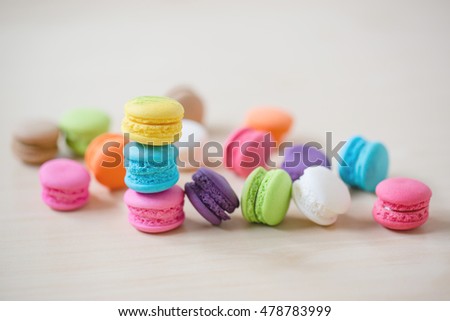 Colorful mini macaroons isolated on wood background