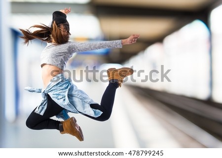 Girl jumping in hip hop style on unfocused background