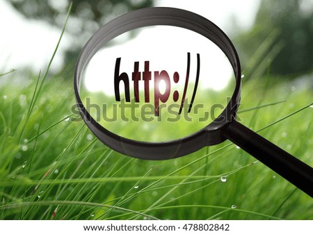 Magnifying glass with the word address bar (http) on grass background. Selective focus