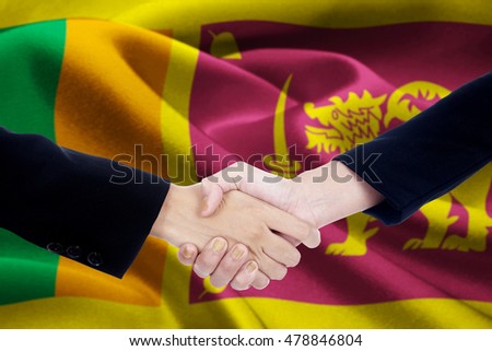 Picture of a negotiation handshake with two entrepreneur hands closing a deal and shaking hands in front of a national flag of Sri Lanka