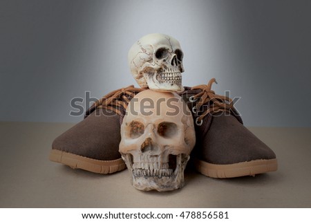 Still Life photography with Human Skull and Baby brown shoes on wooden table