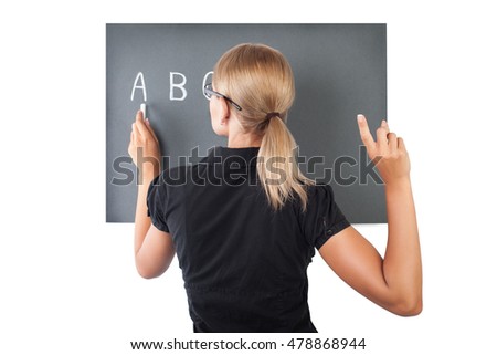 Rear view of a beautiful young teacher isolated on white background, serious female writing letters on the blackboard, teaching in elementary school