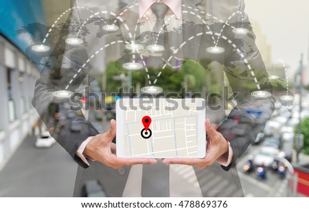 Businessman holding a tablet showing part of navigator map on connection line over the world map with blurred photo of traffic jam, Navigation concept,Elements of this image furnished by NASA
