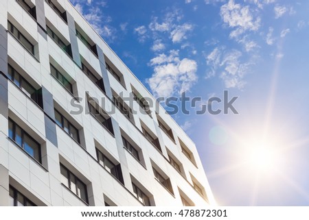 Office building modern architecture on cloudy sky with sun background