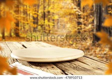 free space on wooden top place and autumn background of forest in golden colors 