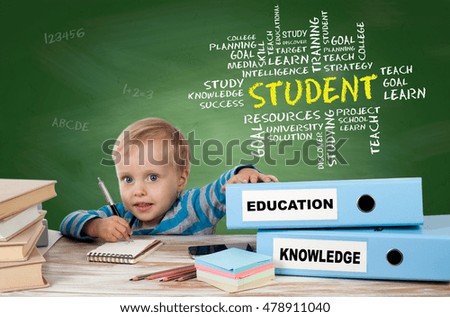 STUDENT, education concept. Young boy sitting at the office desk and two binders