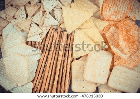 Vintage photo, Heap of crunchy salted potato crisps, breadsticks and cookies, concept of restriction eating unhealthy and salted food
