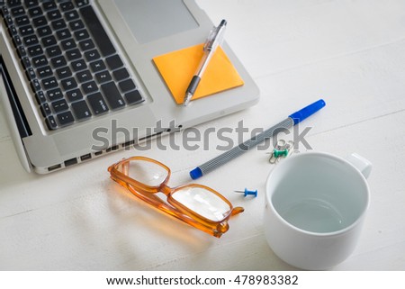 Notebook and pen Business workplace with laptop on the wooden table.with reflection from windows.