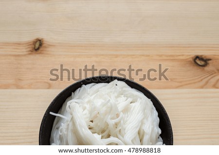 Close up of Thai vermicelli eaten with curry, Thai Food, rice vermicelli in black bowl on wooden table