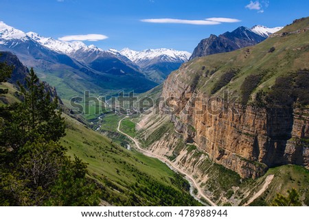 Mountain gorge, view from above on the road. In the background the snow-capped peaks. Chegem