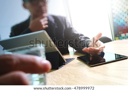 Businessman hand touching digital tablet.Photo finance manager working new Investment project office.Using new technology device.Graphic icons.Strategy business stock exchanges interface layer effect