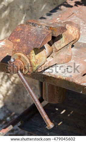 old rusty vise on a metal table