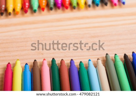 Colorful markers pens on a wooden table