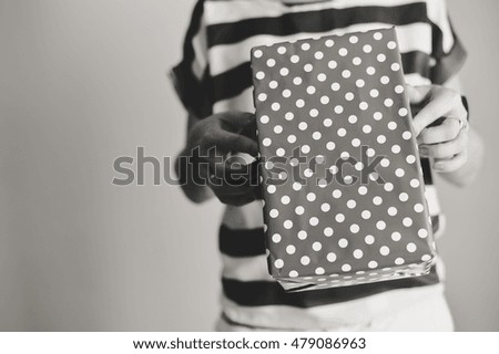 Hand of a person with mobile phone and box on background. Delivery service application on smartphone. Close up image