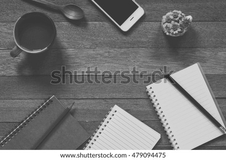 Office stuff and it gadgets display on top view business desk with copy space at text of picture. Filter effect vintage tone film. Creative table, modern project dark style. Black and white.