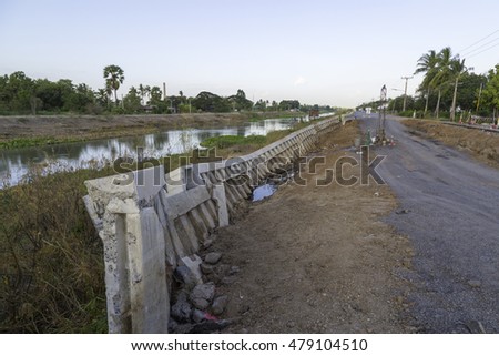 the picture of road destroyed and next to canal in Thailand  
