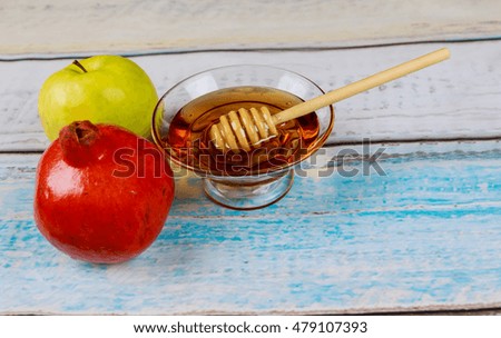 Pomegranate, apple and honey, traditional food of jewish New Year celebration, Rosh Hashana. Selective focus. background