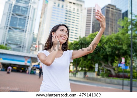 Woman using mobile phone to take selfie