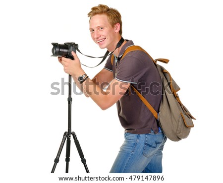 Young man traveler taking pictures by dslr camera on tripod isolated on white