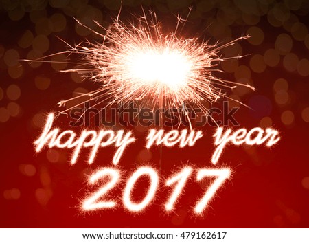 Happy new year 2017 written with Sparkle firework over bokeh background