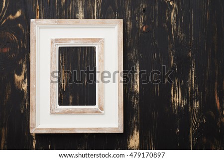 Vintage white empty frame on dark wooden wall