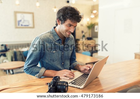 Photographer checking his digital pictures on laptop in agency