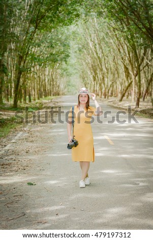 Women photographer on the road in the forest.