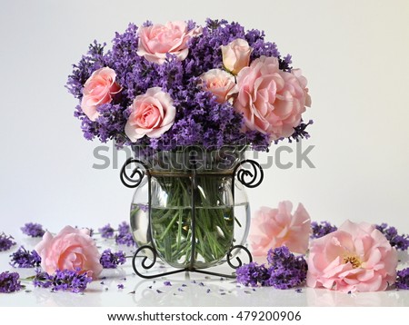 Bouquet of lavender flowers and pink roses in a vase. Romantic floral still with bunch of pink roses and purple lavender in a french vase. Shabby chic style.