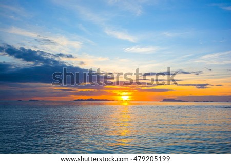 VIEW BEAUTIFUL SUNSET REFLECTING ON WATER AT SEASIDE  , TWILIGHT SKY CLOUD ABOVE THE ISLAND