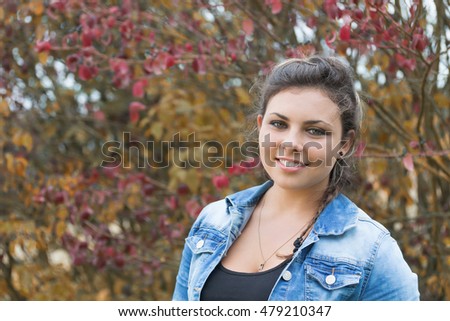 Portrait of smiling teenage girl outdoors. Photo is edited in autumn colors