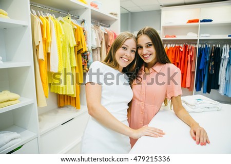 Young beautiful women at the weekly cloth market - Best friends sharing free time having fun and shopping .Girlfriends enjoying everyday life moments. Shopping concept.