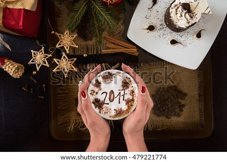 Hands holding mug of coffee close-up, on new year background