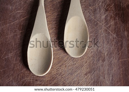 Wooden grunge cutting board surface with empty wooden spoons