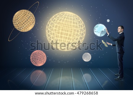 Businessman touching 3d models of planets of the Solar System, surrounded by stars. Global business. New opportunities. Unlimited possibilities,