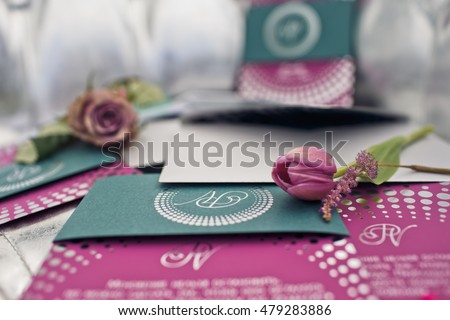 Tulips and lavander lie on the green and pink invitation cards