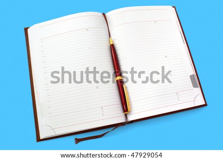 Opened everyday notebook with ball pen isolated on cyan background
