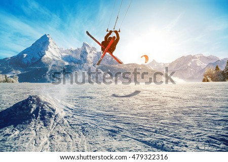Young men, skiing on frozen lake in the mountains, in the rays of the rising sun, in winter, on vacation Royalty-Free Stock Photo #479322316