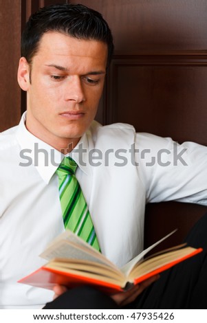 Male business professional reading book of paragraph