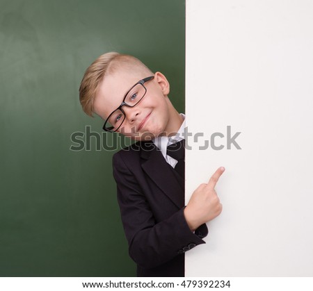 Boy in a business suit pointing at blank placard.