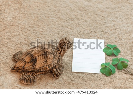 The wooden turtle this character is waiting for someone to write the notes down on paper the white, with the clover overlap.