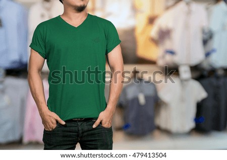 Man wearing blank t-shirt on Abstract blurred photo of clothing store in a shopping mall, shopping concept
