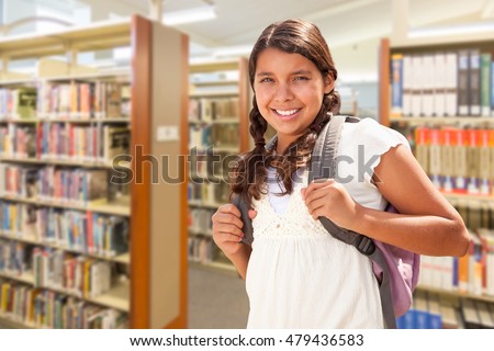 Happy Hispanic Girl Student Wearing Backpack Walking in the Library.